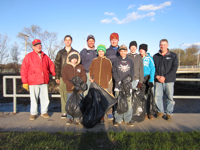 Boy Scouts of Melrose Troop 68 clean trash along river shoreline.