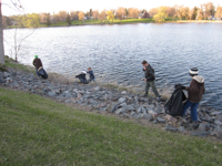 Boy Scouts of Melrose Troop 68 clean trash along river shoreline.